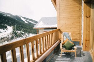 A wooden deck with a chair and pillows on it.